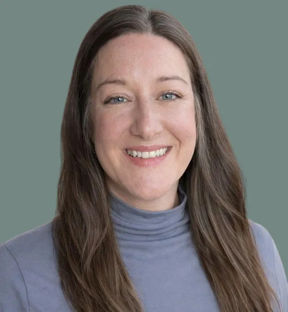 Portrait of woman with long brown hair and blue eyes smiling