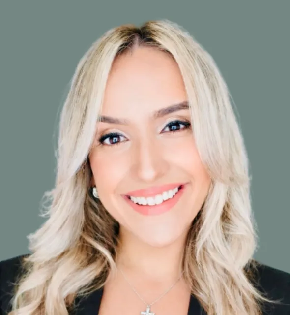 Portrait of a woman with blonde hair and a white smile